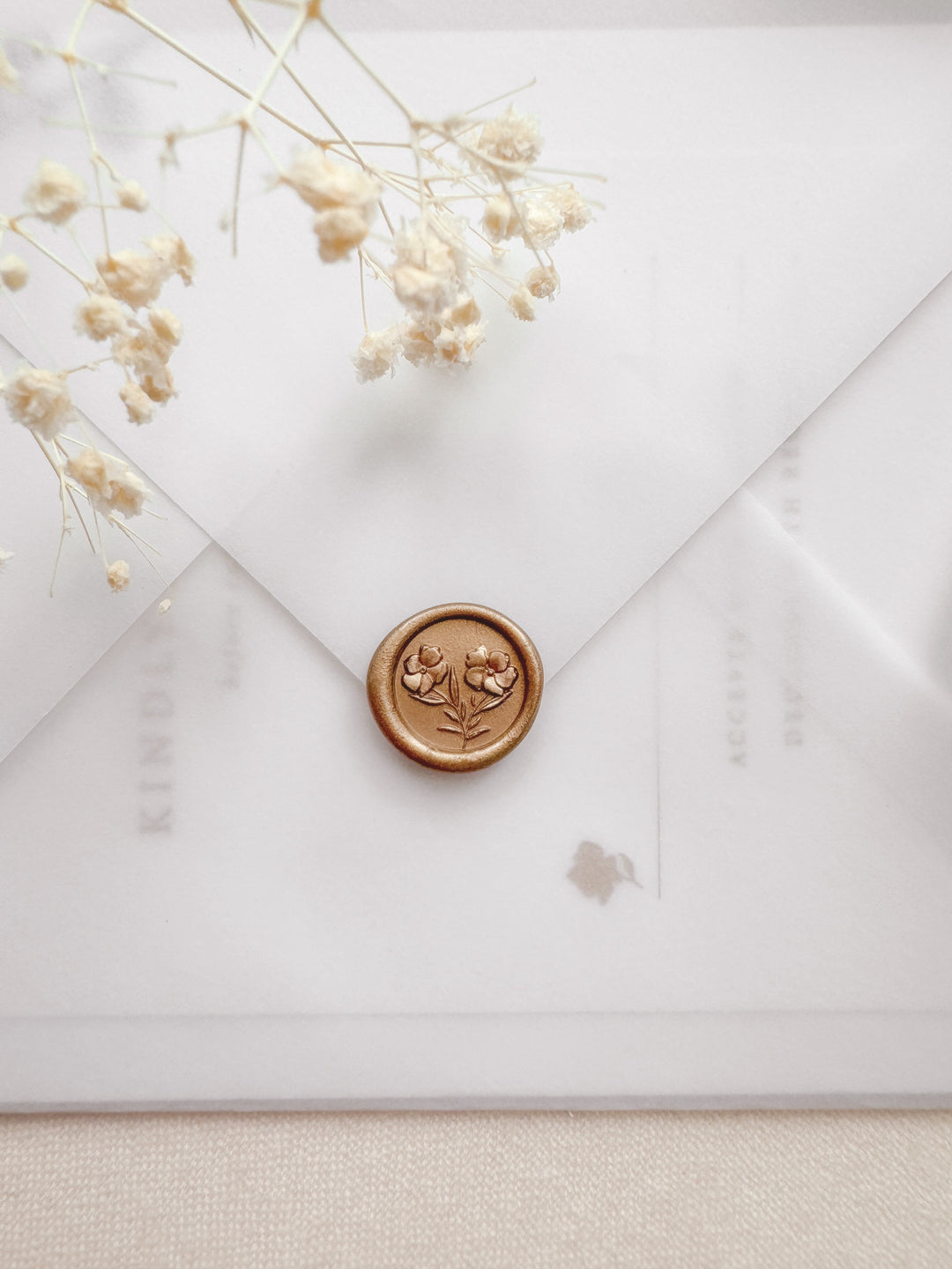 peachy gold mini gardenia flower wax seal on a vellum wedding invitation envelope 