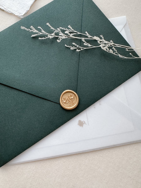 Mini light gold wax seal featuring gardenia flowers with 3D engravings on a dark green envelope