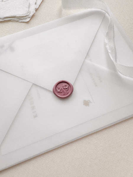 Dusty rose colored mini wax seal featuring gardenia flowers with 3D engravings on a vellum envelope