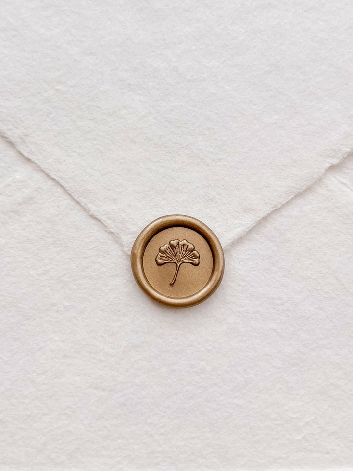 classic gold 3D mini ginkgo wax seal on a white deckle-edge handmade paper wedding envelope flap