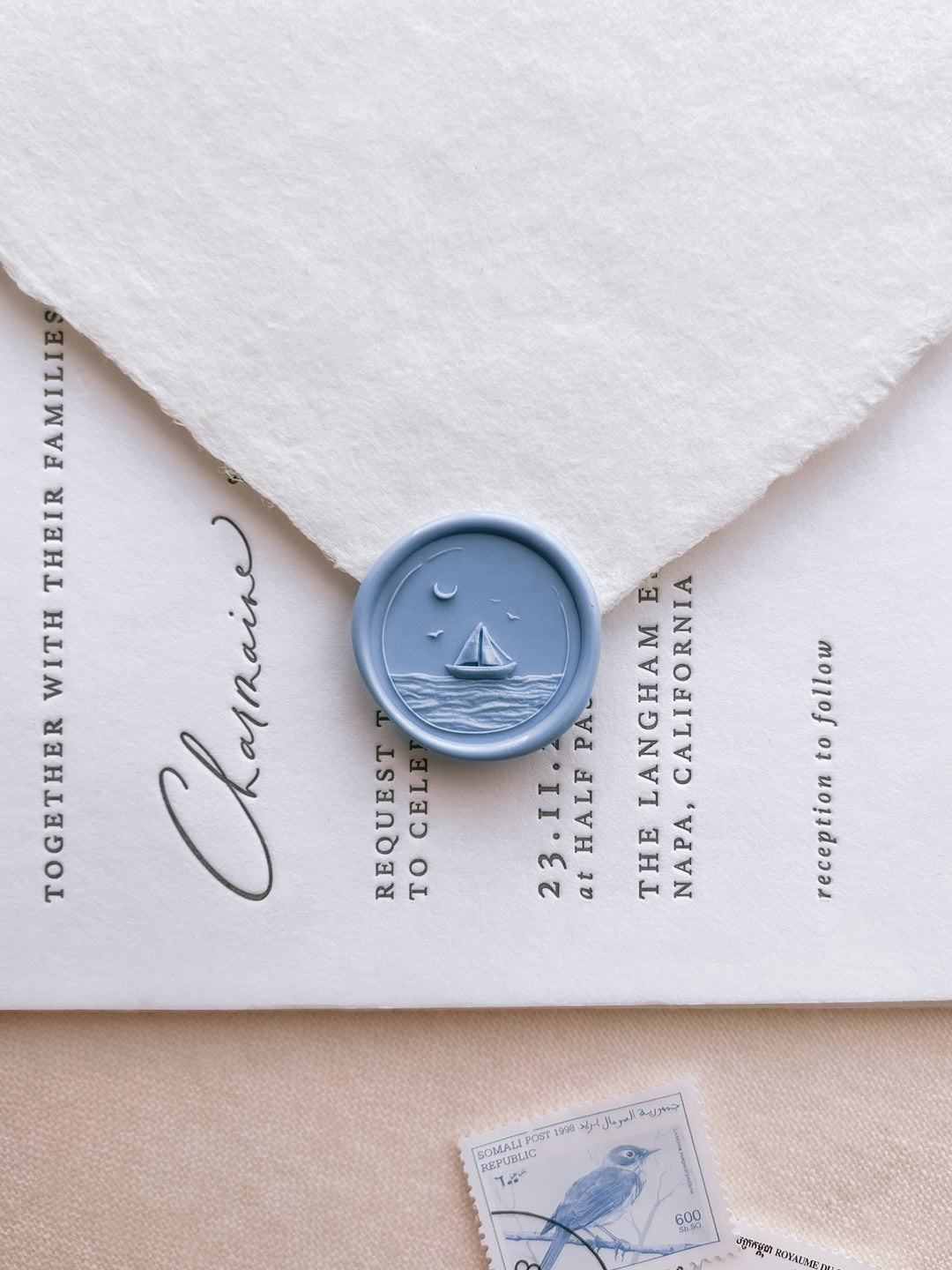 sailboat ocean waves design blue wax seal with 3D engraving on a white letterpress wedding invitation card and white envelope 