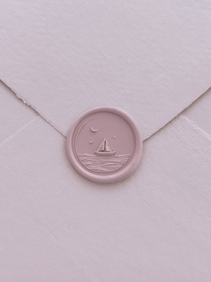 Light pink 3D sailboat and ocean waves wax seal on a light pink handmade paper envelope