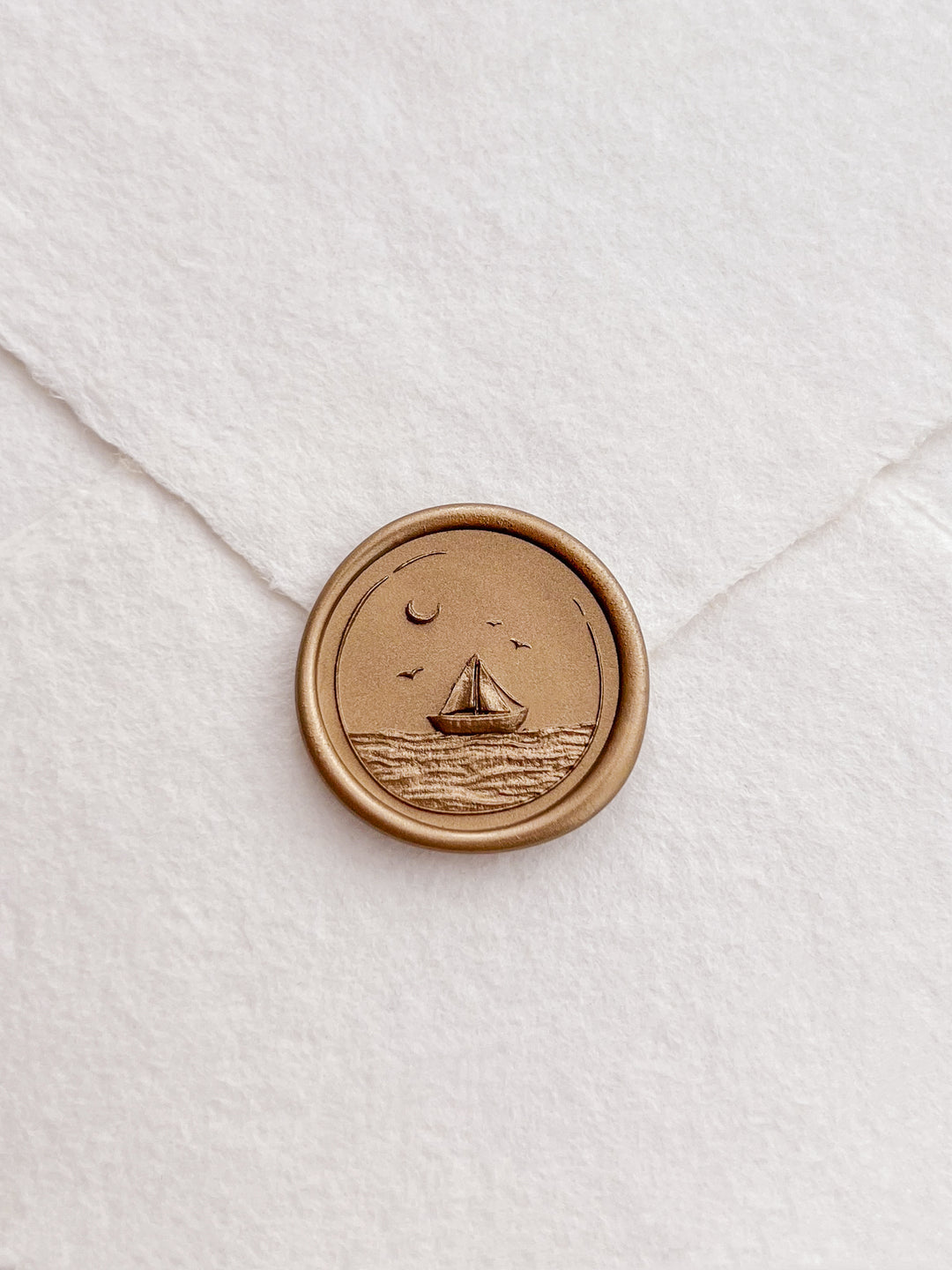 Sailboat and ocean waves design gold wax seal on a white envelope 