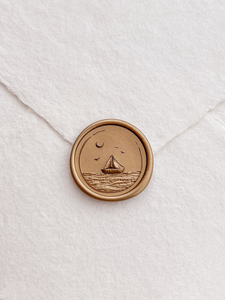 Sailboat and ocean waves design gold wax seal on a white envelope 