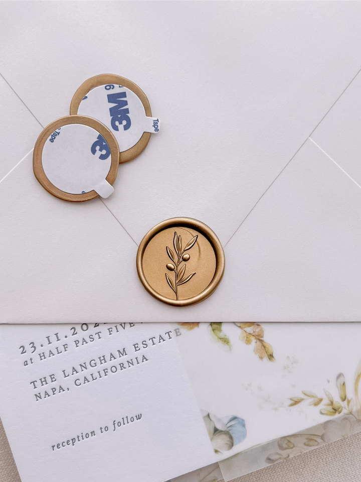 3D olive branch gold wax seal stickers with self-adhesive backings on a wedding invitation, beige envelope, and floral vellum jacket