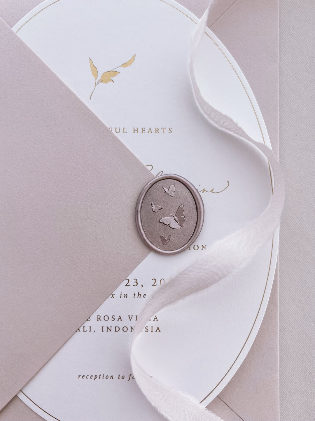mocha 3D oval butterflies wax seal on a cream arched wedding invitation and a dusty rose envelope