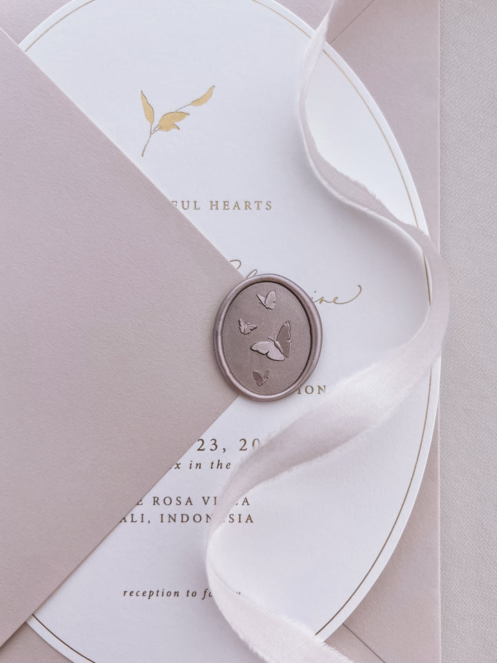 mocha 3D oval butterflies wax seal on a cream arched wedding invitation and a dusty rose envelope