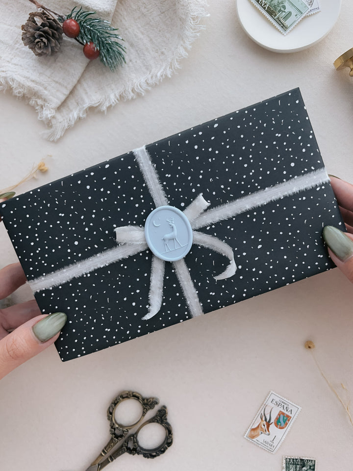 Light blue 3D reindeer oval wax seal on a wrapped Christmas gift