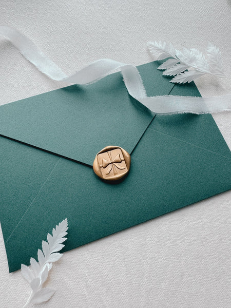 gold 3D festive bow wax seal on Christmas card envelope