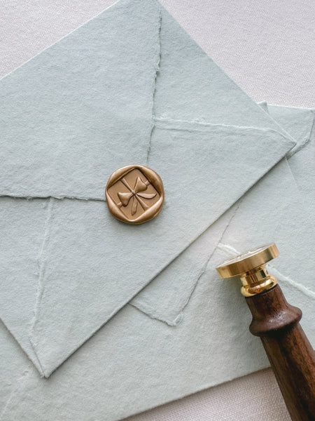 gold 3D ribbon bow wax seals on sage handmade paper envelopes