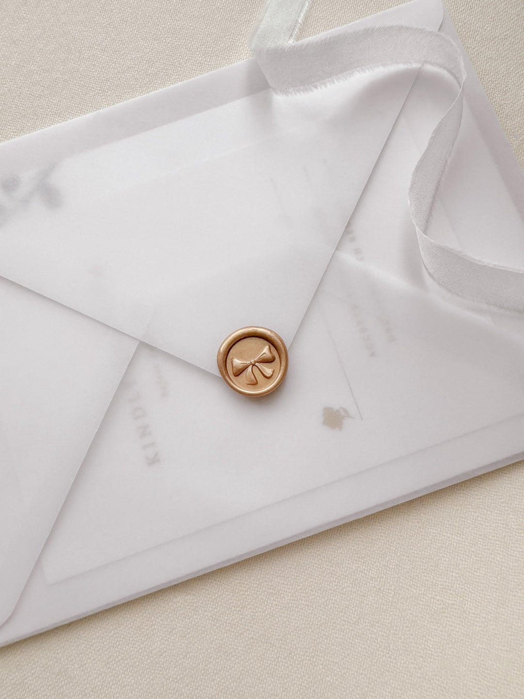 Orange gold 3D ribbon bow mini wax seal on a vellum wedding invitation envelope 