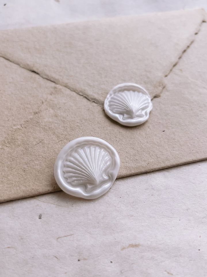 Pearl white 3D seashell die-cut wax seals on a light brown handmade paper envelope