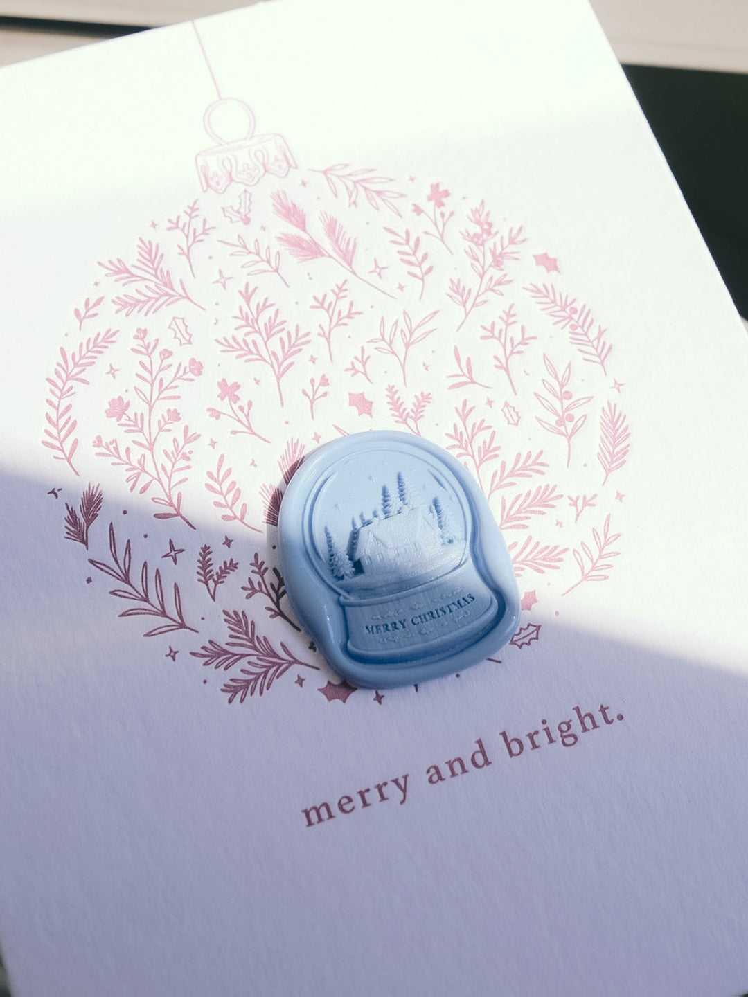 Merry Christmas snow globe blue wax seal on a festive ornament Christmas card printed with the greeting &
