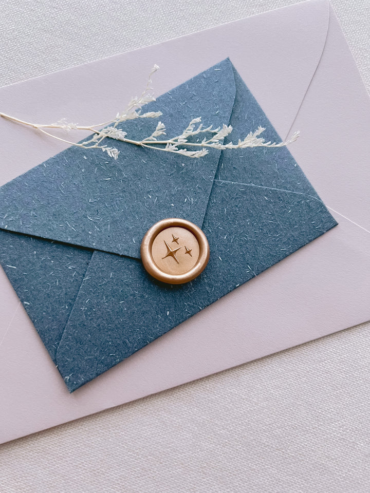 Peachy gold stars wax seal on a dark blue textured mini envelope