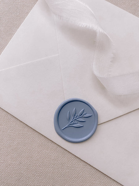 3D Leaf Branch Wax Seal in blue on paper envelope styled with a strand of white ribbon