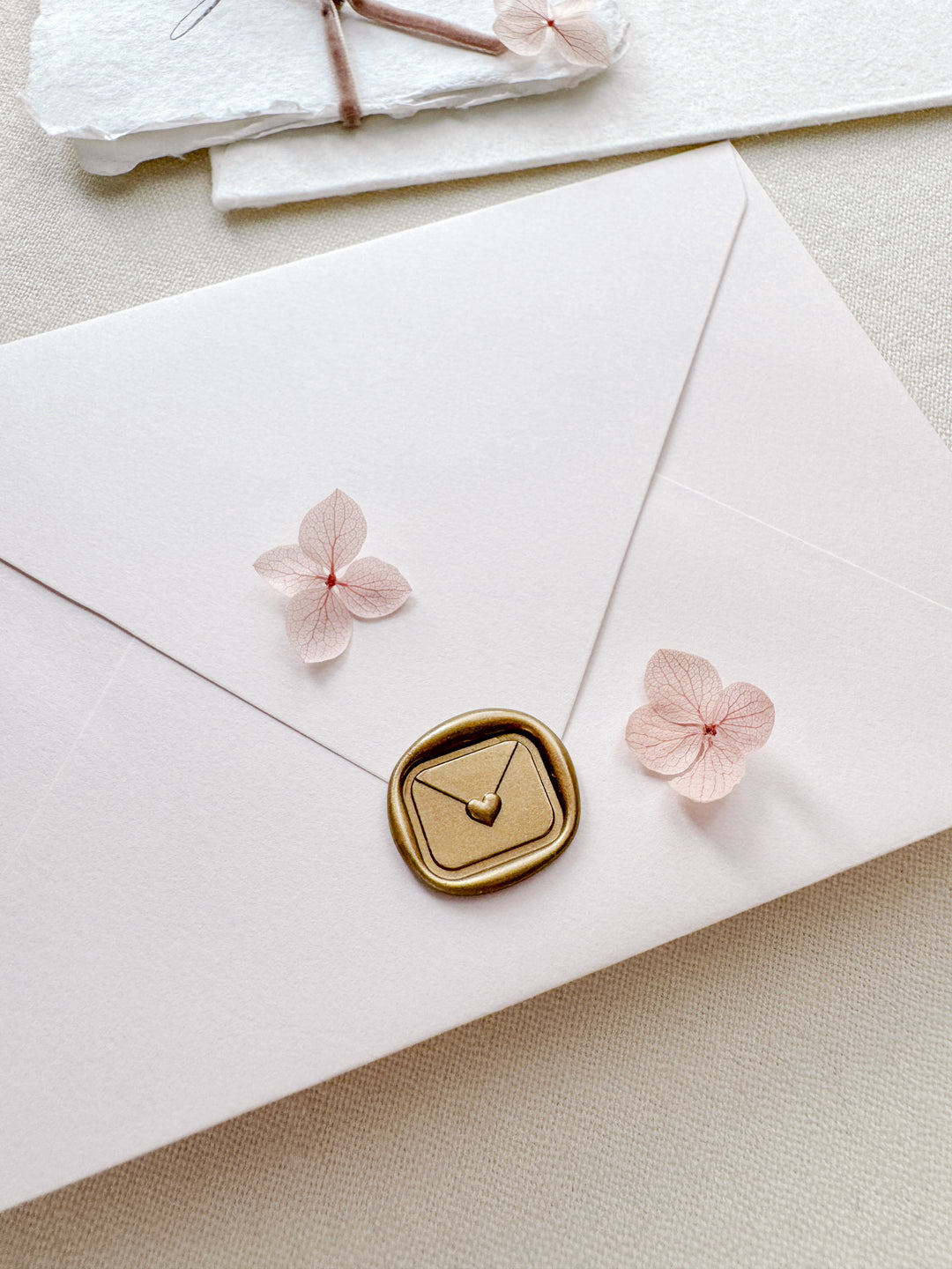 Gold 3D mini heart sealed envelope rectangular wax seal on a white envelope
