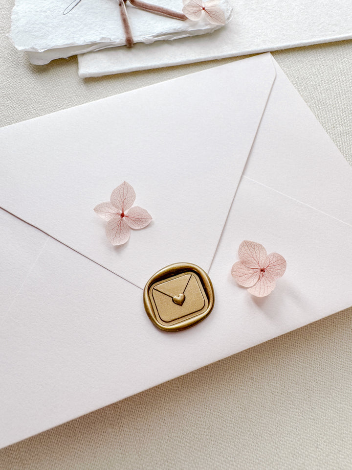Gold 3D mini heart sealed envelope rectangular wax seal on a white envelope