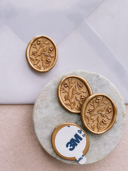 Oval floral wax seals with 3D engraving in gold with 3m sticker on small gray stone dish