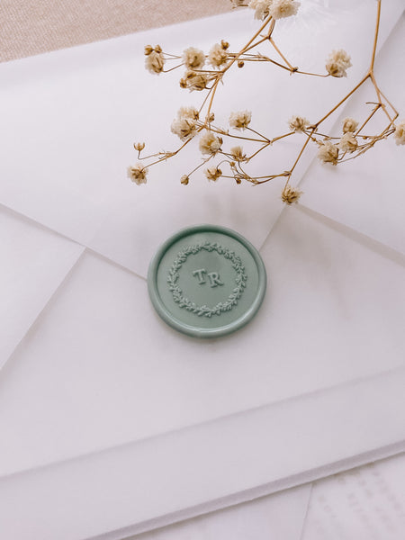 Leaf wreath monogram sage green custom wax seal on vellum envelope styled with dried flowers