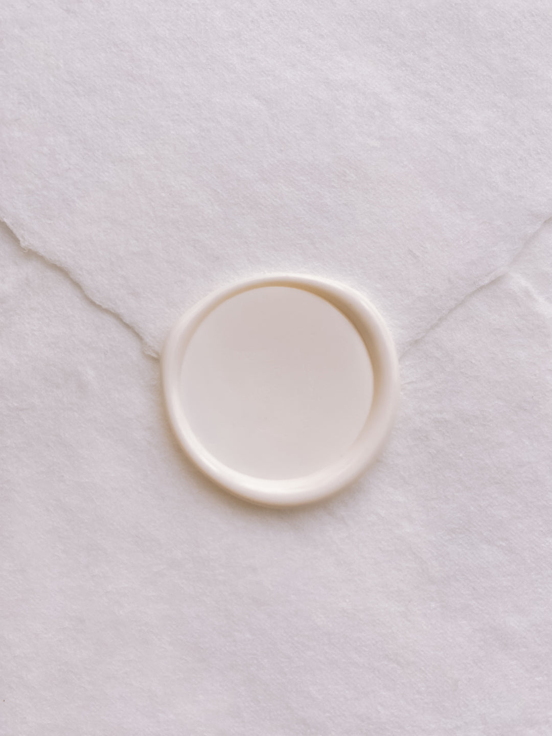 Off-white blank wax seal on white handmade paper envelope