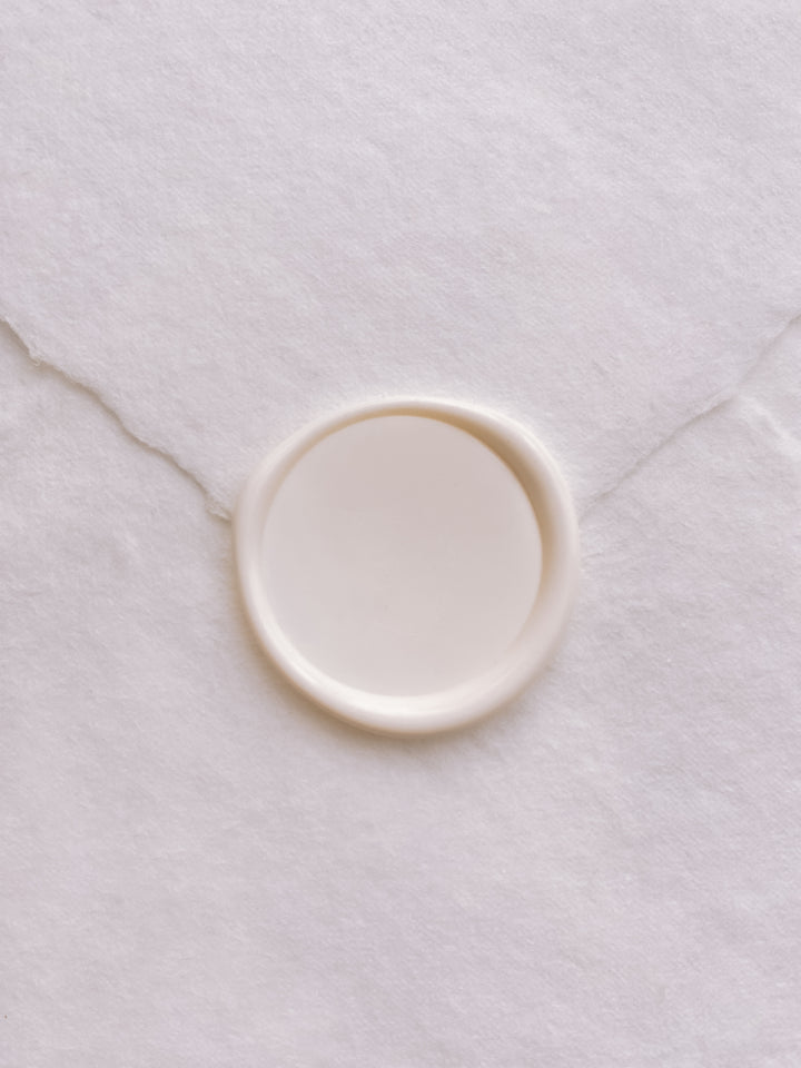Off-white blank wax seal on white handmade paper envelope