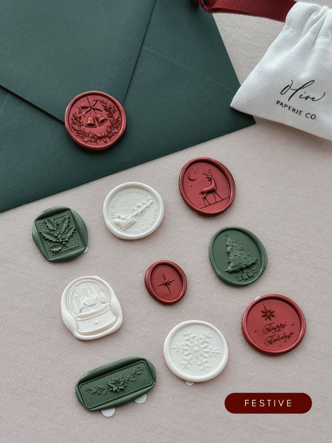 Assorted Christmas wax seal stickers in deep red, dark green and ivory — ten festive designs styled with a dark green envelope and linen pouch.