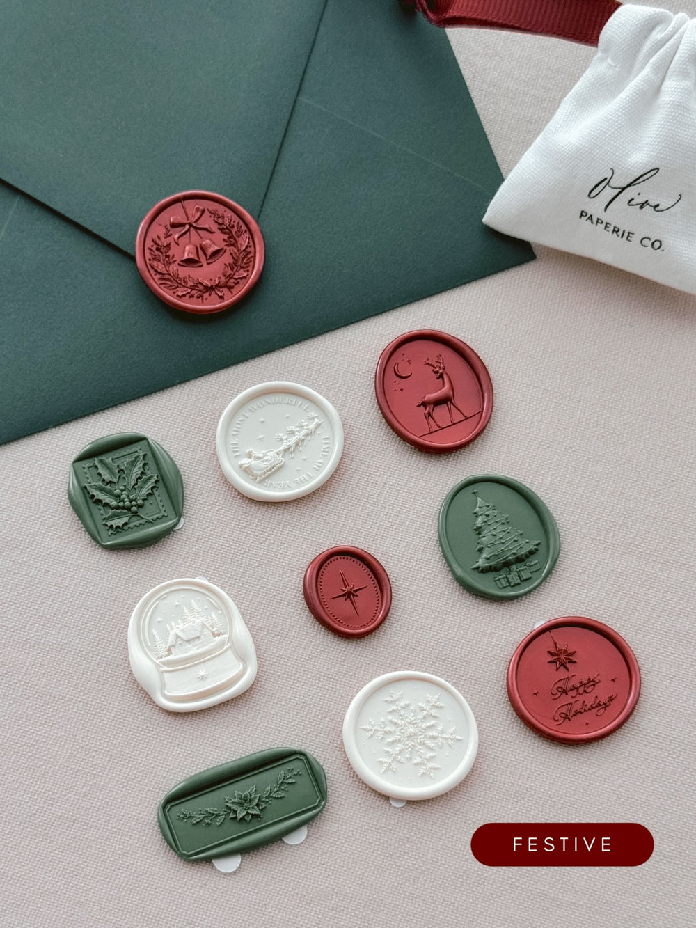 Assorted Christmas wax seal stickers in colors metallic red, dark green and antique white in various festive motifs including Christmas wreath, holly, Santa sleigh, reindeer, snow globe, North Star, Christmas tree and more.