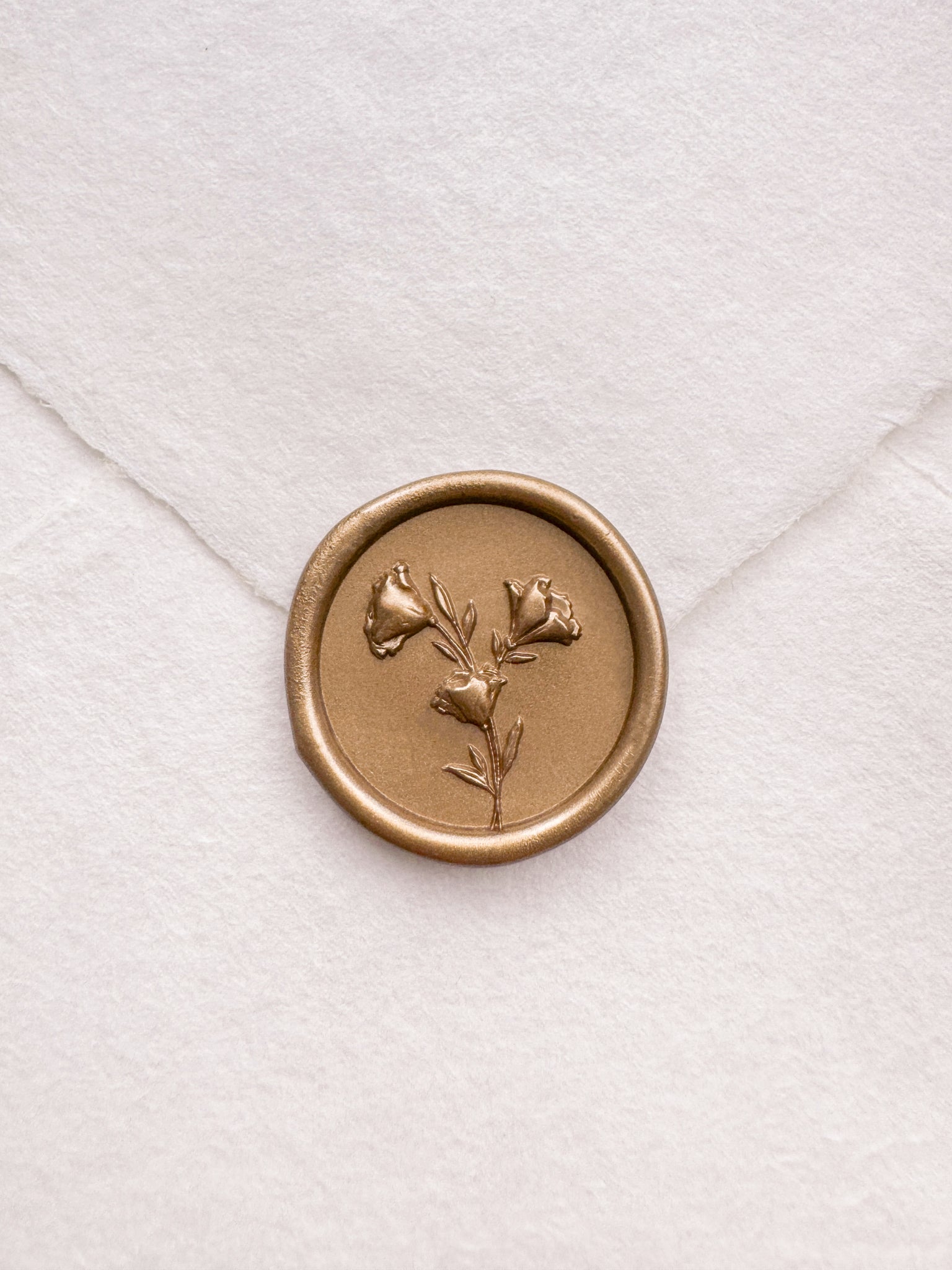 Floral design gold wax seal with 3D engraving details on a white handmade paper envelope