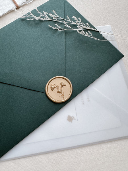 Floral design light gold wax seal with 3D engraving details on a dark green envelope
