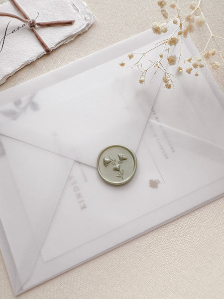 Floral design wax seal in a light metallic sage green color with 3D engraving details on a vellum envelope