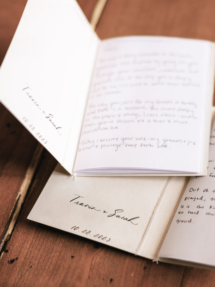 Beige vow books showing inner cover personalized with the couple&