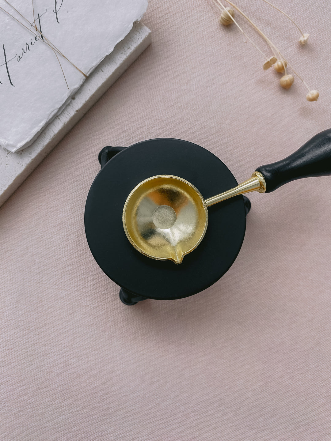 Black color melting stove with gold color melting spoon_top view