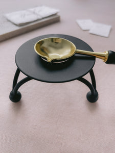 black color melting stove with gold color melting spoon 
