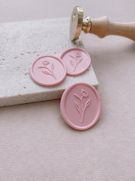 simple oval flower wax seals in blush color with brass head wax seal stamp in wooden handle