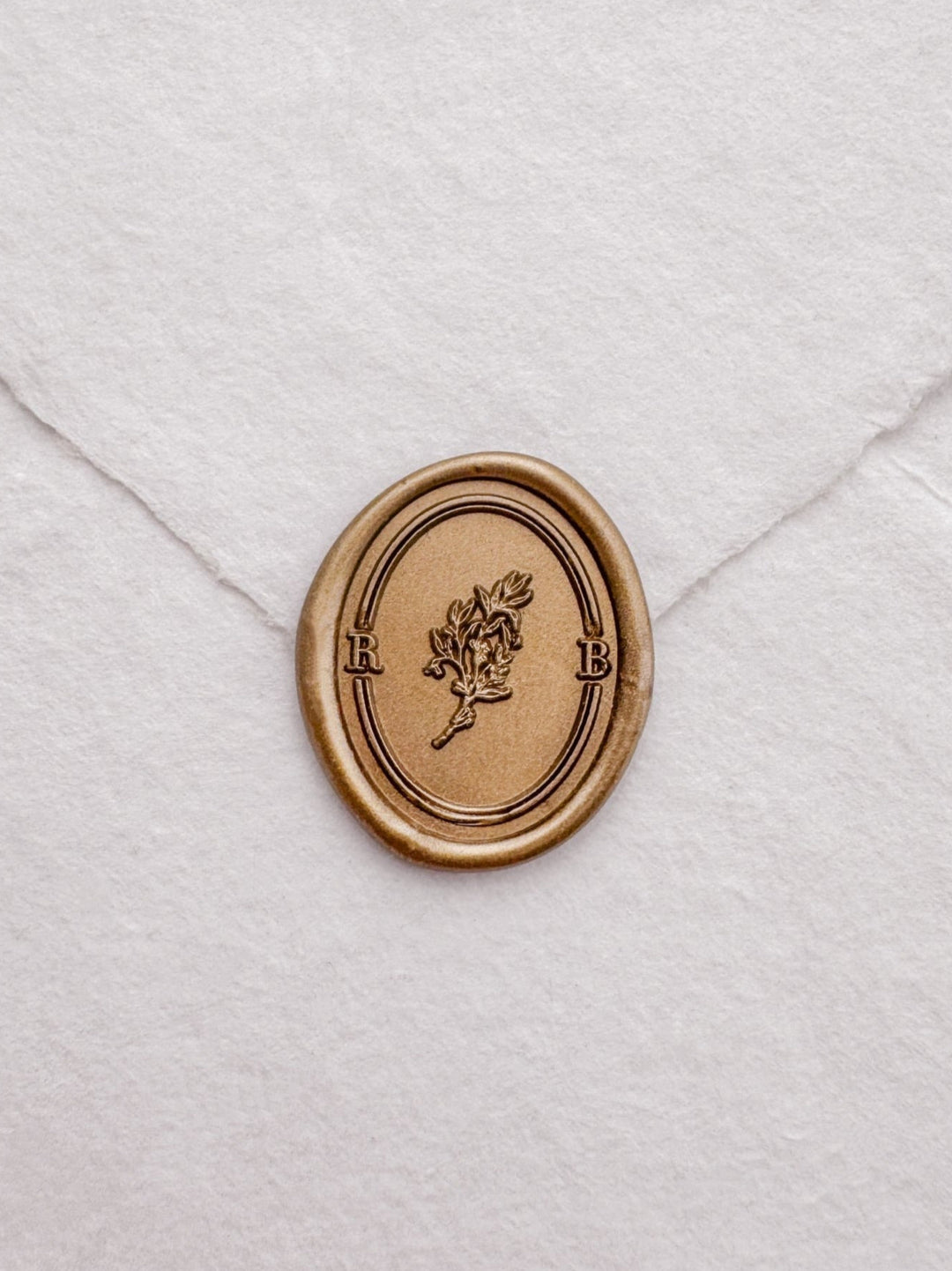 custom initials gold wax seal with a botanical leaf branch and double border design 
