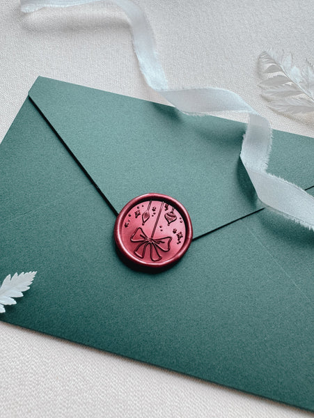 metallic red Christmas ornaments wax seal on green holiday card envelope