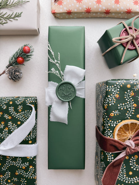 dark green festive ornaments wax seal on a Christmas gift