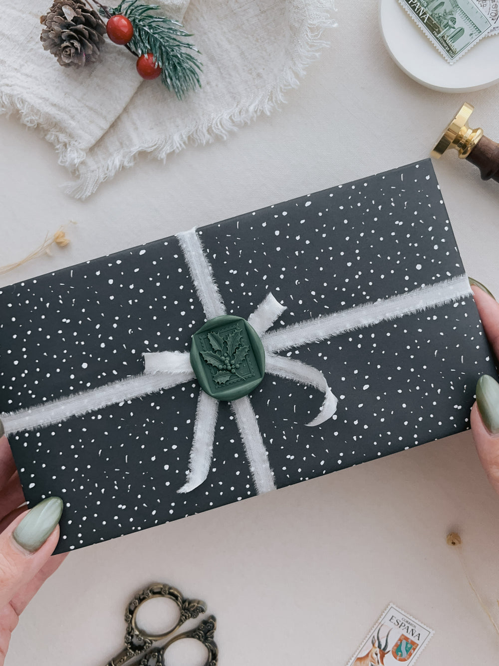 Dark green Christmas holly leaf 3D wax seal on a wrapped gift