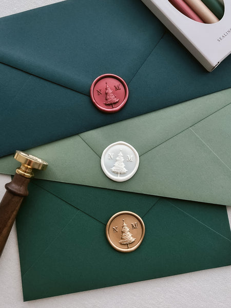 Personalized Christmas tree custom initials wax seals in red, white and gold on green Christmas card envelopes