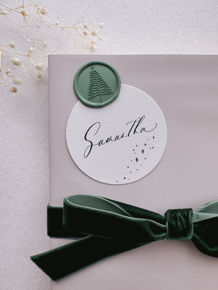 green Christmas tree wax seal on personalized holiday gift tag