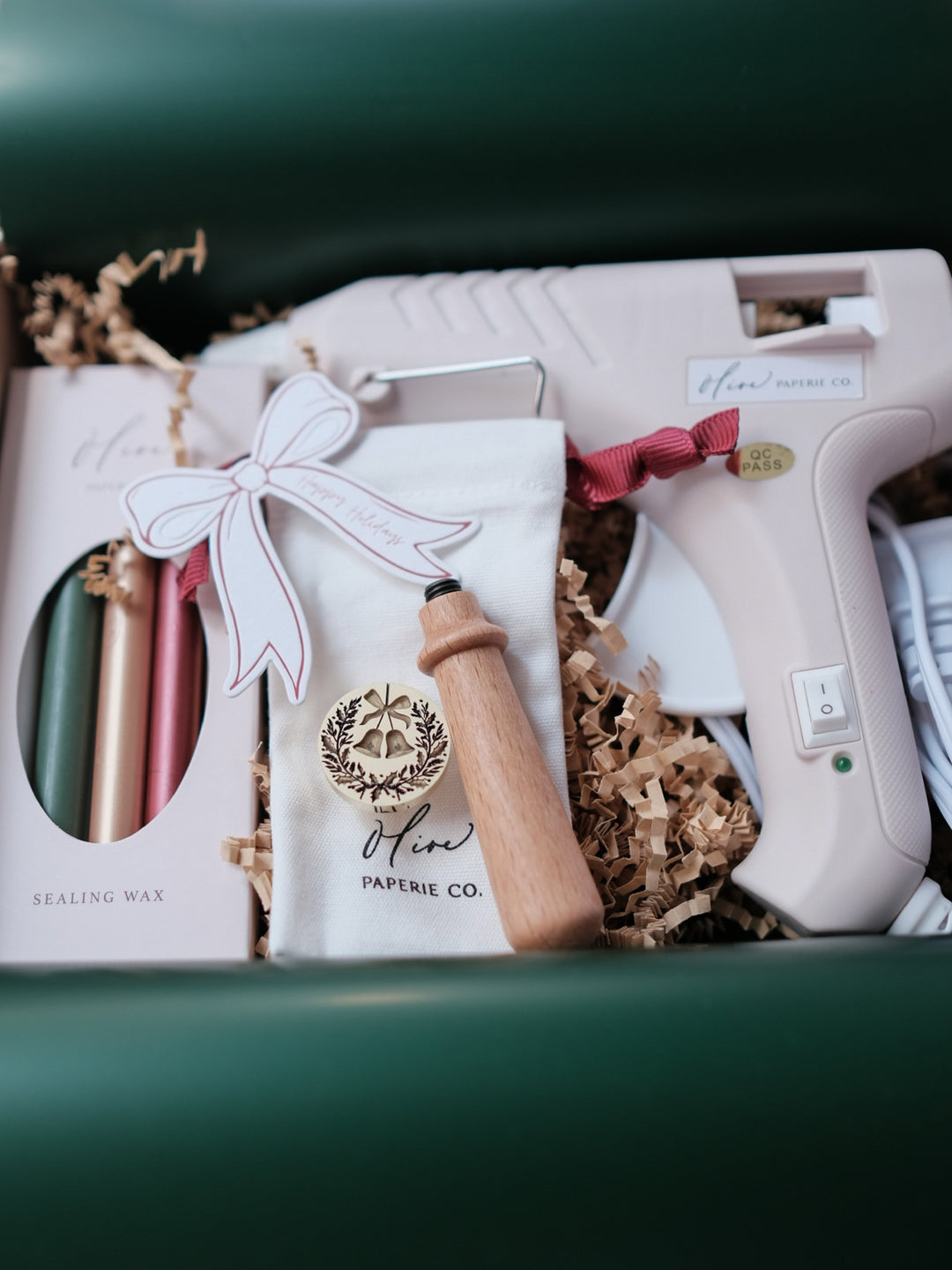 Christmas wax seal kit with a festive wax stamp, hot glue gun, wooden handle, and festive colored sealing wax sticks