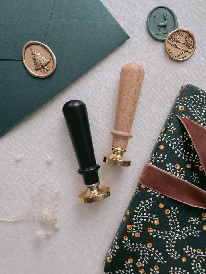 Wax seal stamps with black and wooden handles, Christmas card with a Christmas tree wax seal and a wrapped Christmas gift