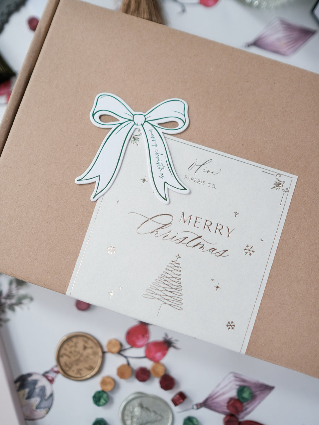 Festive wax seal kit gift box packaging with a green die cut bow gift tag