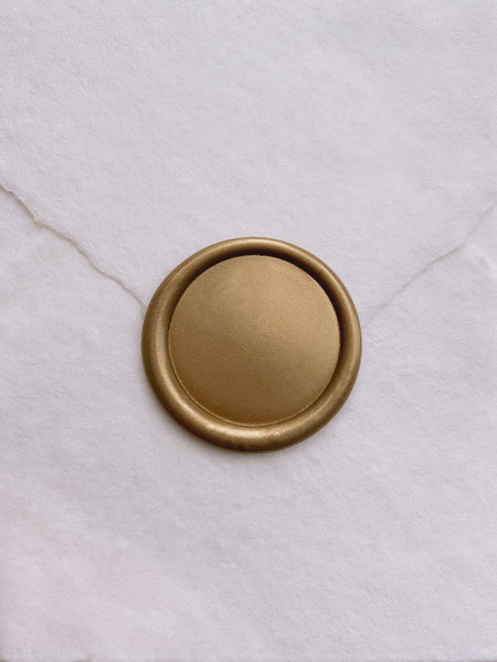 Classic gold blank wax seal on white handmade paper envelope