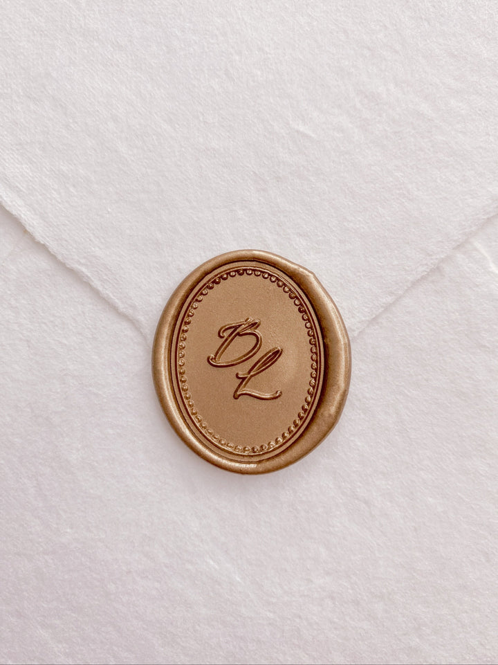 Calligraphy script monogram oval gold wax seal with a border design 