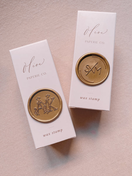 Custom wax seal stamps with gold wax seals attached on packaging boxes