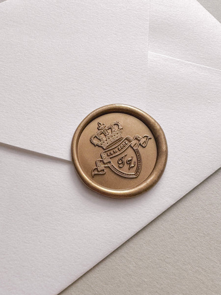 Custom logo gold wax seal featuring a crest symbol design on a white envelope