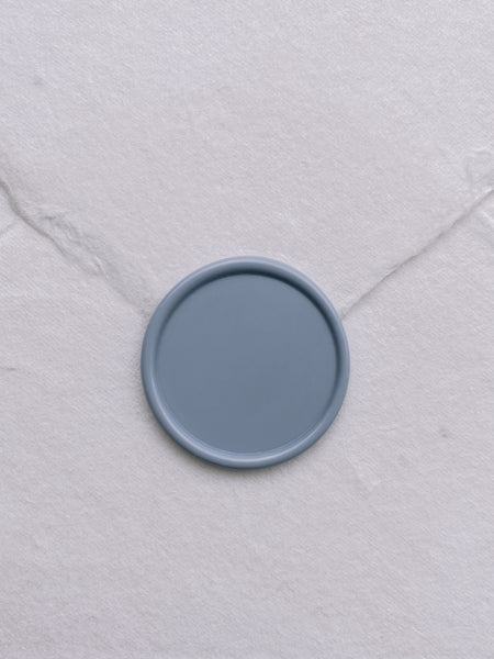 Dusty blue blank wax seal on white handmade paper envelope
