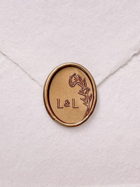 Oval floral monogram gold wax seal on a white handmade envelope