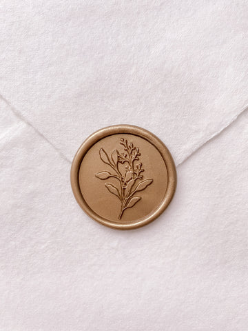 Gold eucalyptus leaf wax seal on white handmade paper envelope